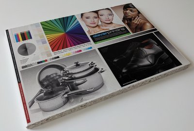 Der Druck zeigt eine Farbpalette, Portraits von Gesichtern sowie Aufnahmen von glänzenden Töpfen und Schuhen