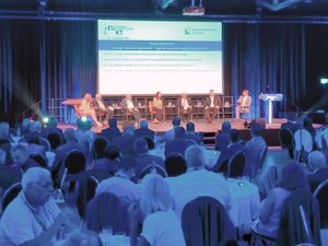Podium Ingenieurkammertag 2025 mehrere Personen sitzen auf einer Bühne und diskutieren, im Saal sind viele Besucher an Tischen